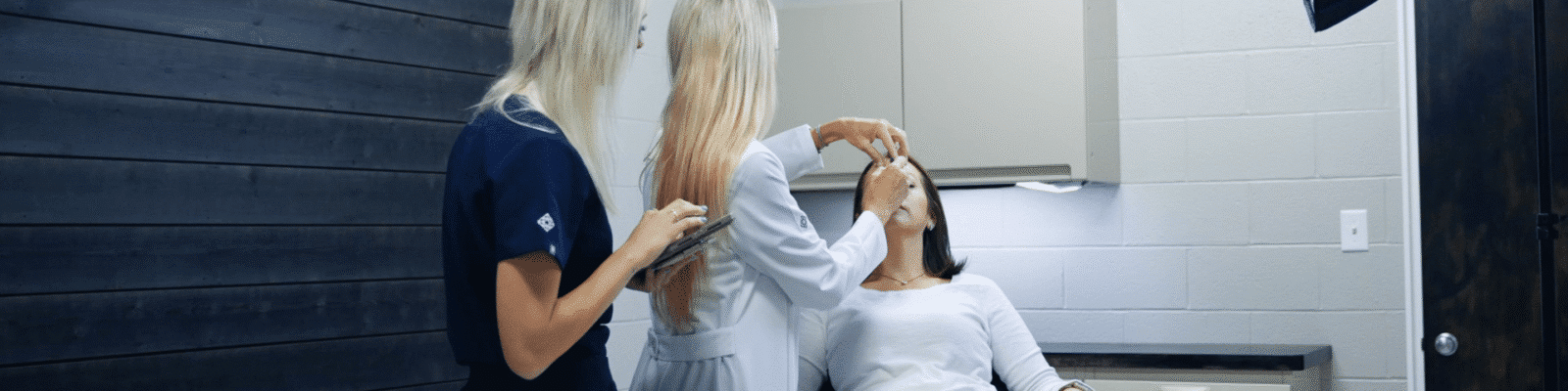 botox Two professionals performing Botox procedure in a cosmetic clinic.