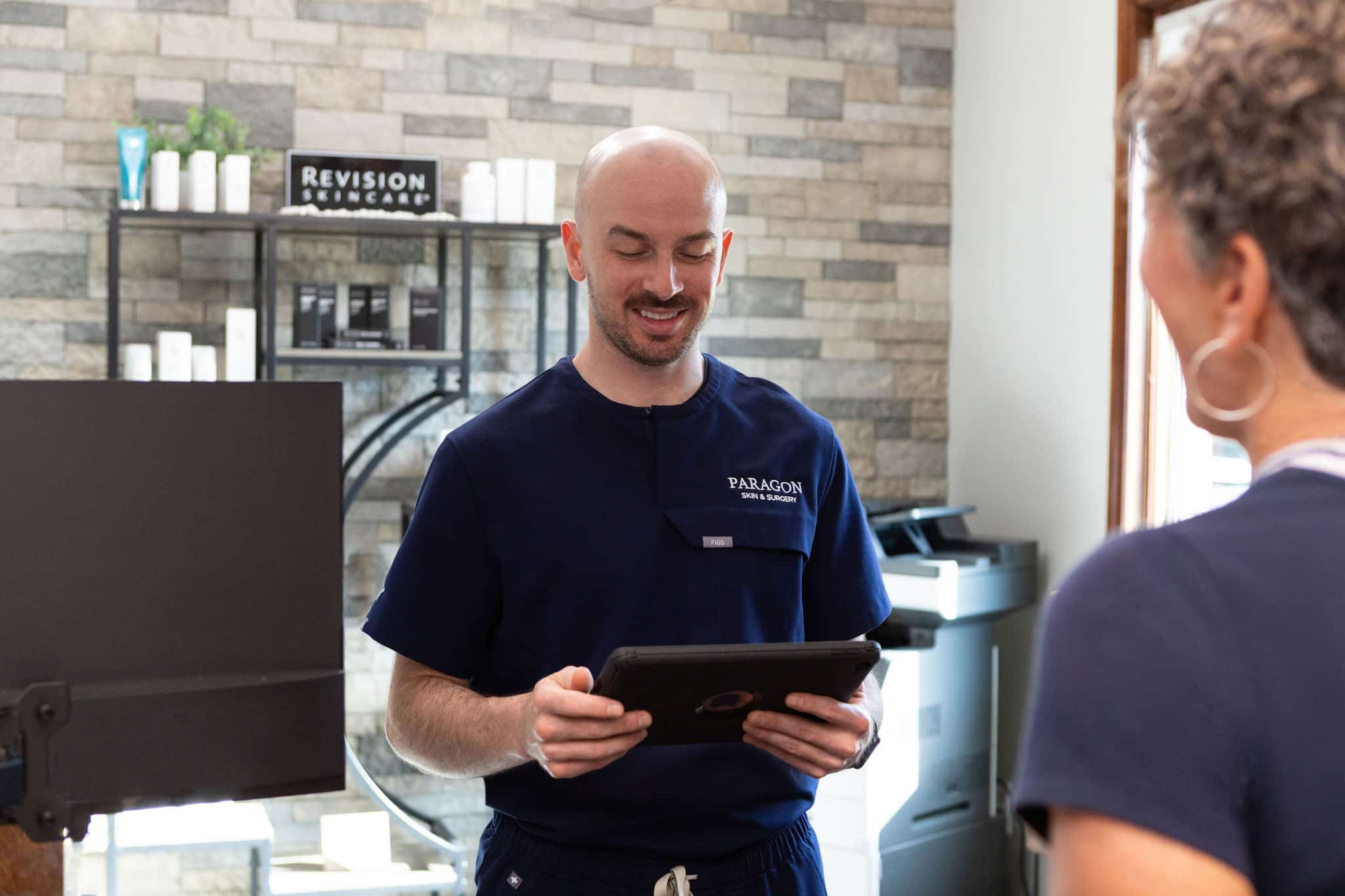 f-8589 Paragon Skin & Surgery team member consulting with a patient in the clinic