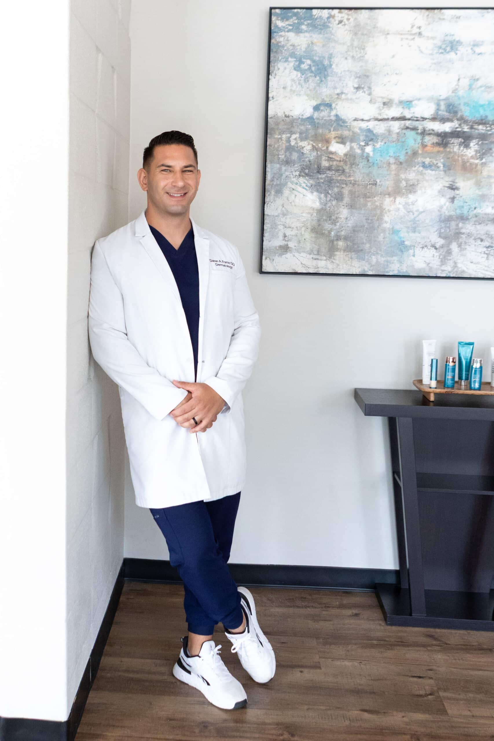 Dermatologist in white coat in a clinic with skincare products displayed