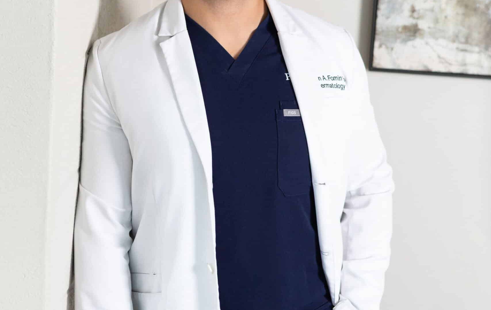Dermatologist in white coat standing in clinic office