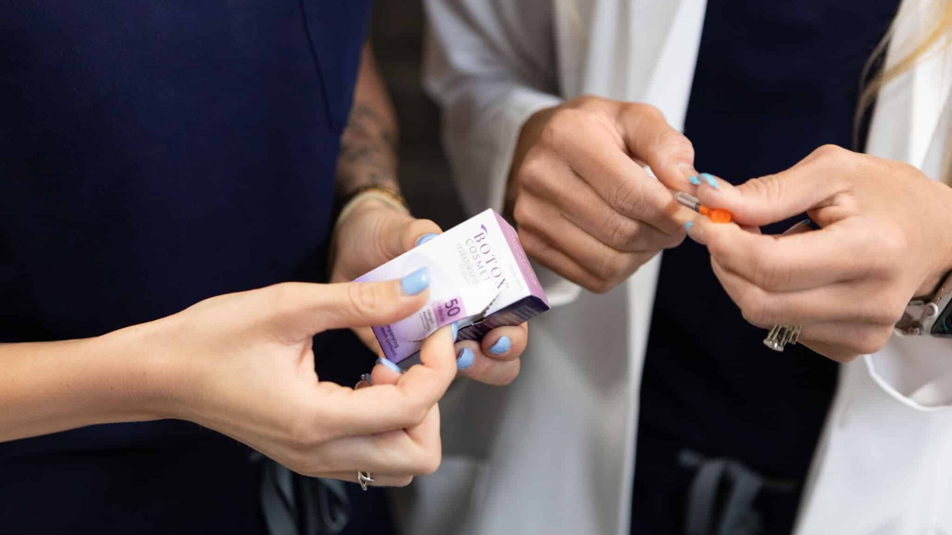 Two professionals handling Botox neurotoxin packaging at clinic