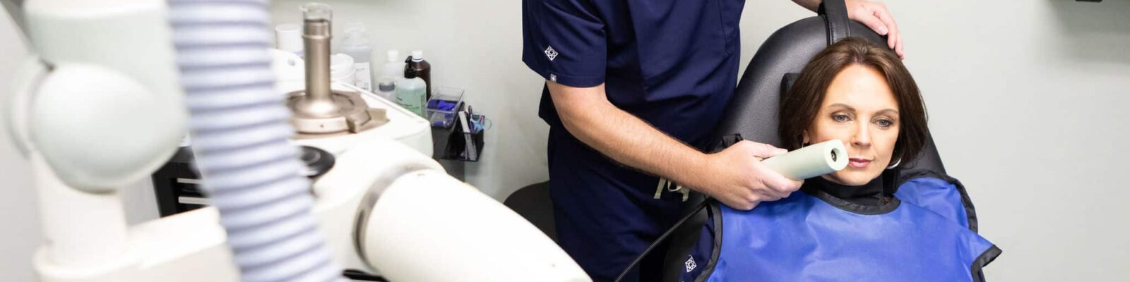 f-9035 Doctor performing a dermal treatment on a patient in a clinic setting.